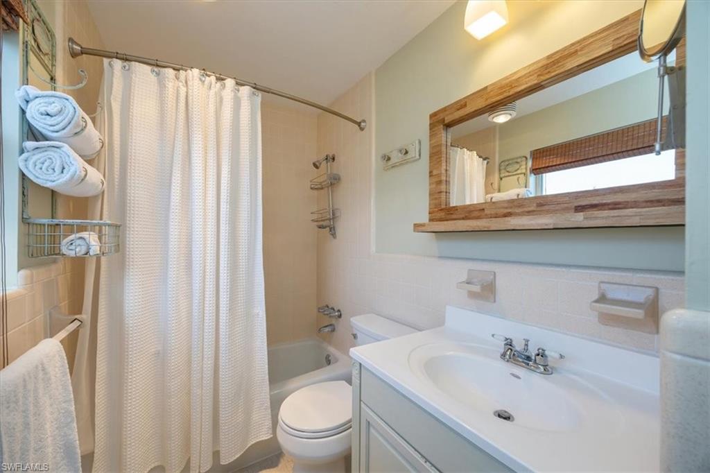 780 10th Avenue South, Unit 24 Naples, FL 34102 - Photo 11 of 15 a bathroom with a sink a toilet and shower curtain