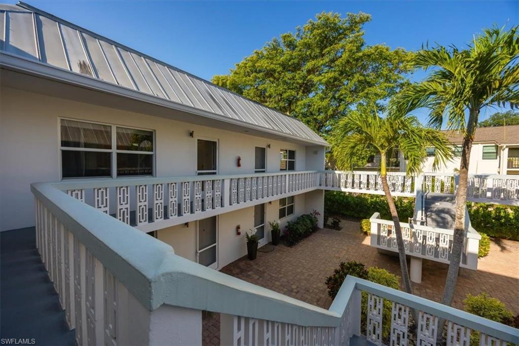 780 10th Avenue South, Unit 24 Naples, FL 34102 - Photo 3 of 15 a balcony with wooden floor and outdoor seating