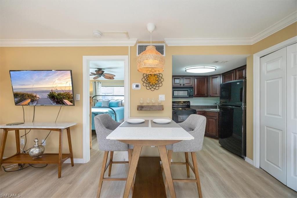 780 10th Avenue South, Unit 24 Naples, FL 34102 - Photo 7 of 15 a view of a dining room with furniture a chandelier and wooden floor