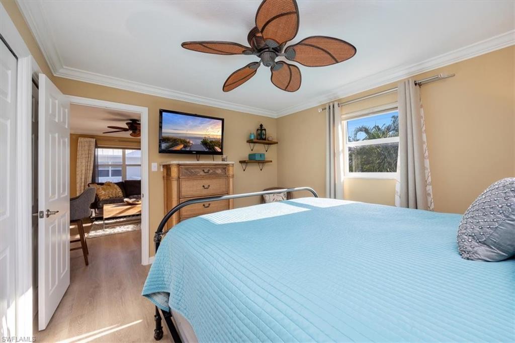 780 10th Avenue South, Unit 24 Naples, FL 34102 - Photo 10 of 15 a bedroom with a bed and a chandelier