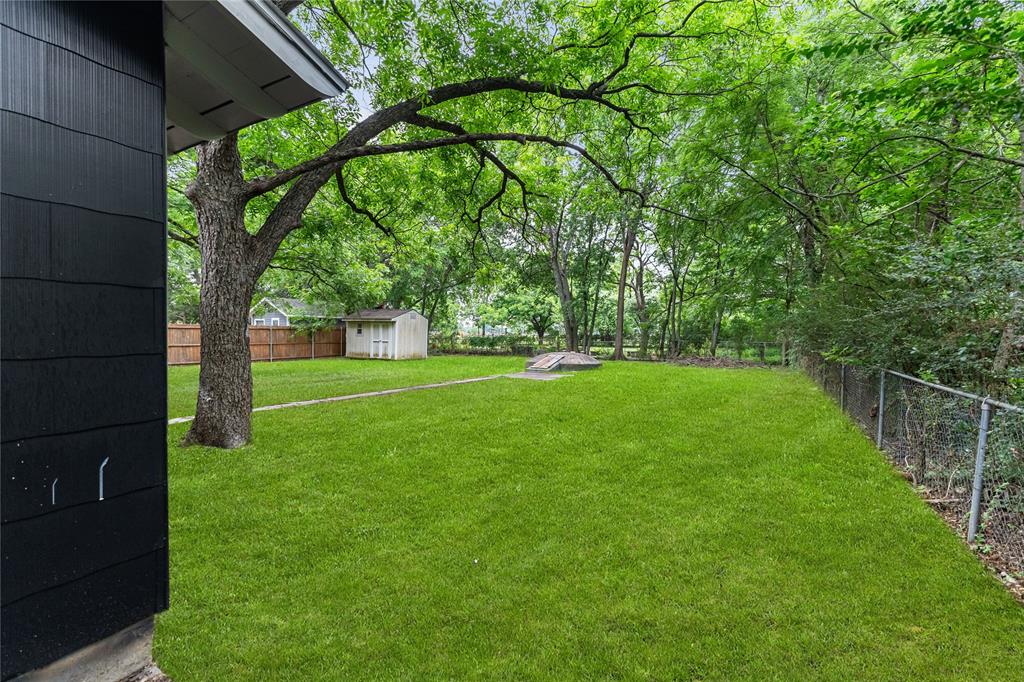 110 Hackberry Street Lancaster, TX 75146 - Photo 30 of 32 Expansive backyard featuring a lush lawn, mature trees, and a storage shed