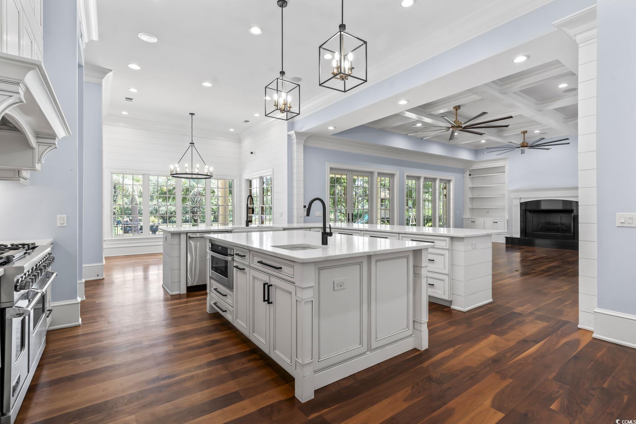 9318 Cove Drive Myrtle Beach, SC 29572 - Photo 40 of 40 Kitchen with open floor plan, pendant lighting, a ceiling fan, a fireplace with raised hearth, and light stone counters