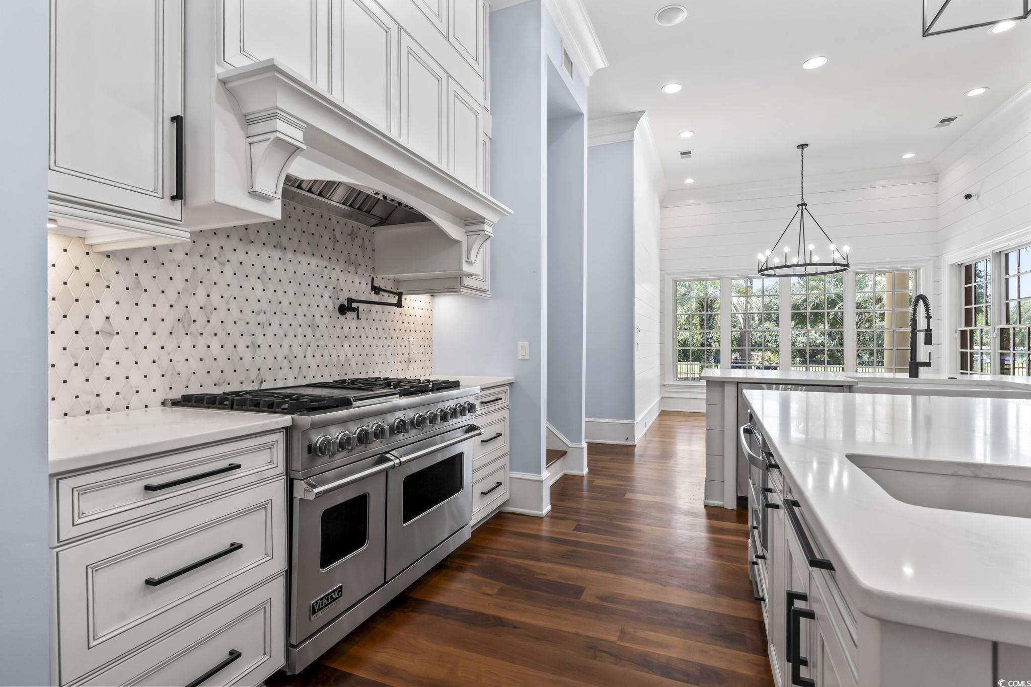 9318 Cove Drive Myrtle Beach, SC 29572 - Photo 13 of 40 Kitchen with range with two ovens, dark wood finished floors, light stone countertops, a chandelier, and decorative light fixtures