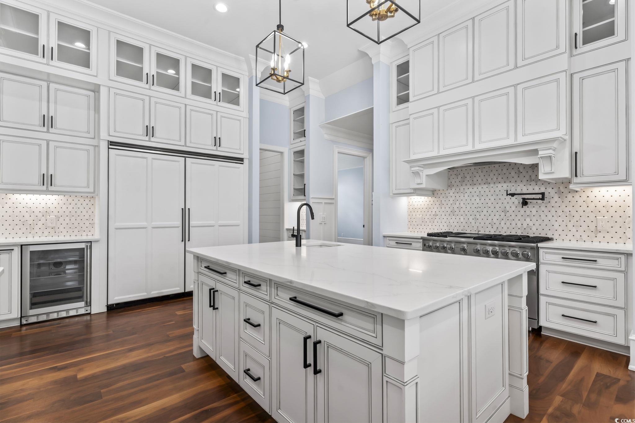 9318 Cove Drive Myrtle Beach, SC 29572 - Photo 14 of 40 Kitchen featuring backsplash, glass insert cabinets, wine cooler, light stone counters, and pendant lighting