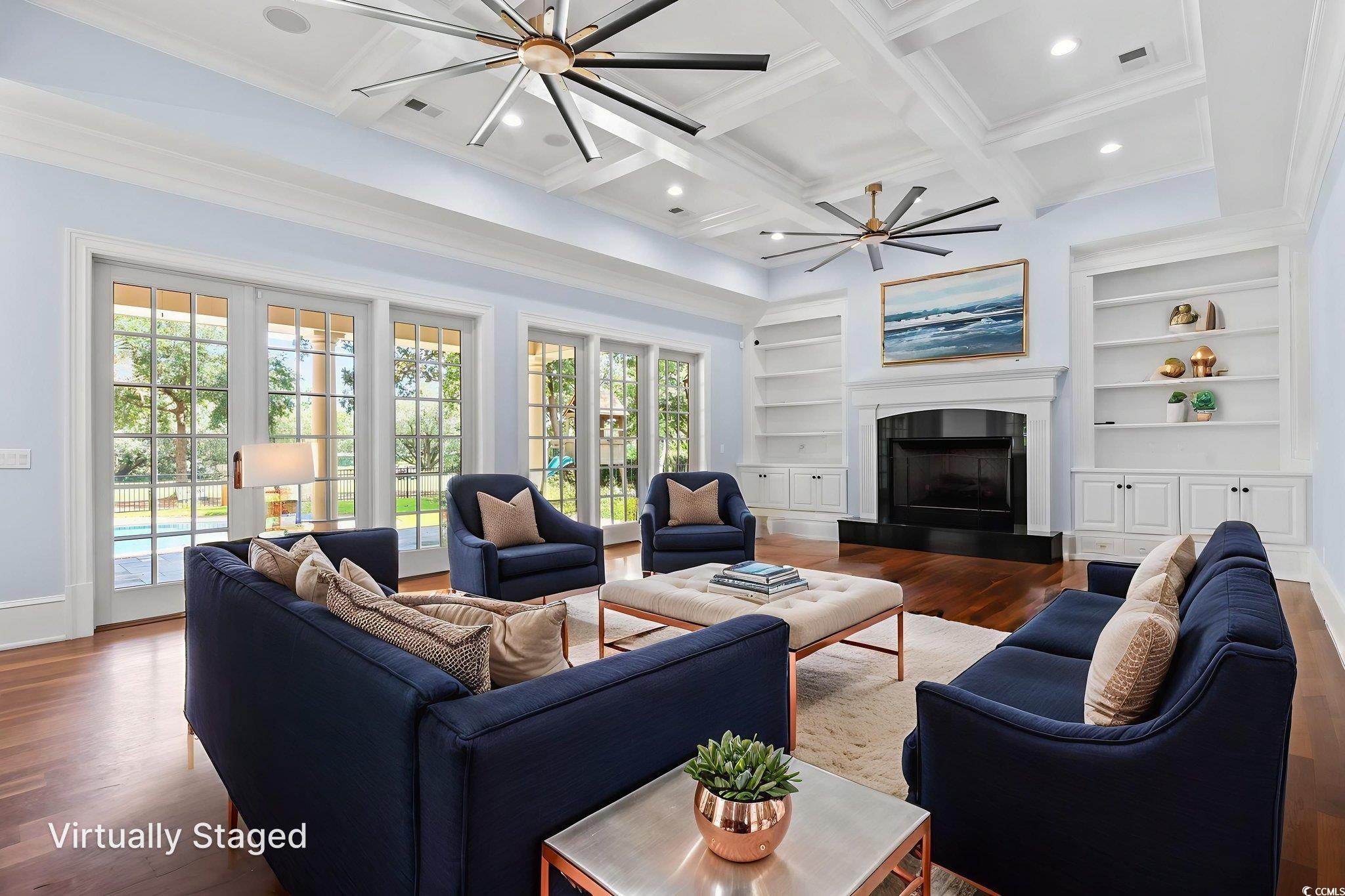 9318 Cove Drive Myrtle Beach, SC 29572 - Photo 18 of 40 Living room with wood finished floors, beamed ceiling, a fireplace with raised hearth, ceiling fan, and built in features