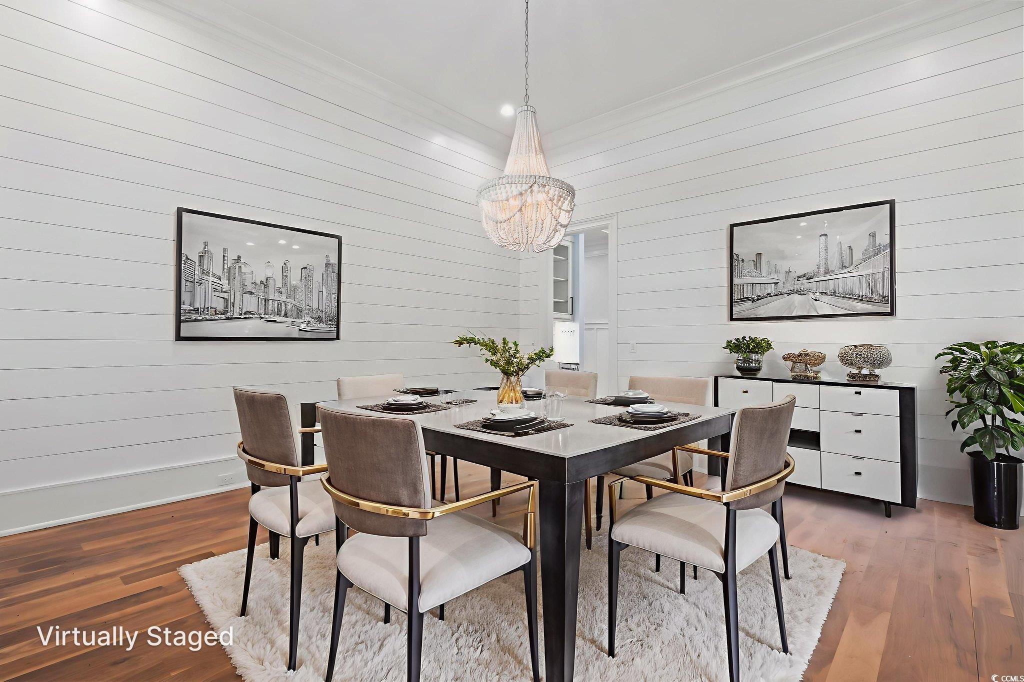9318 Cove Drive Myrtle Beach, SC 29572 - Photo 19 of 40 Dining space with wood finished floors, a chandelier, crown molding, and wood walls