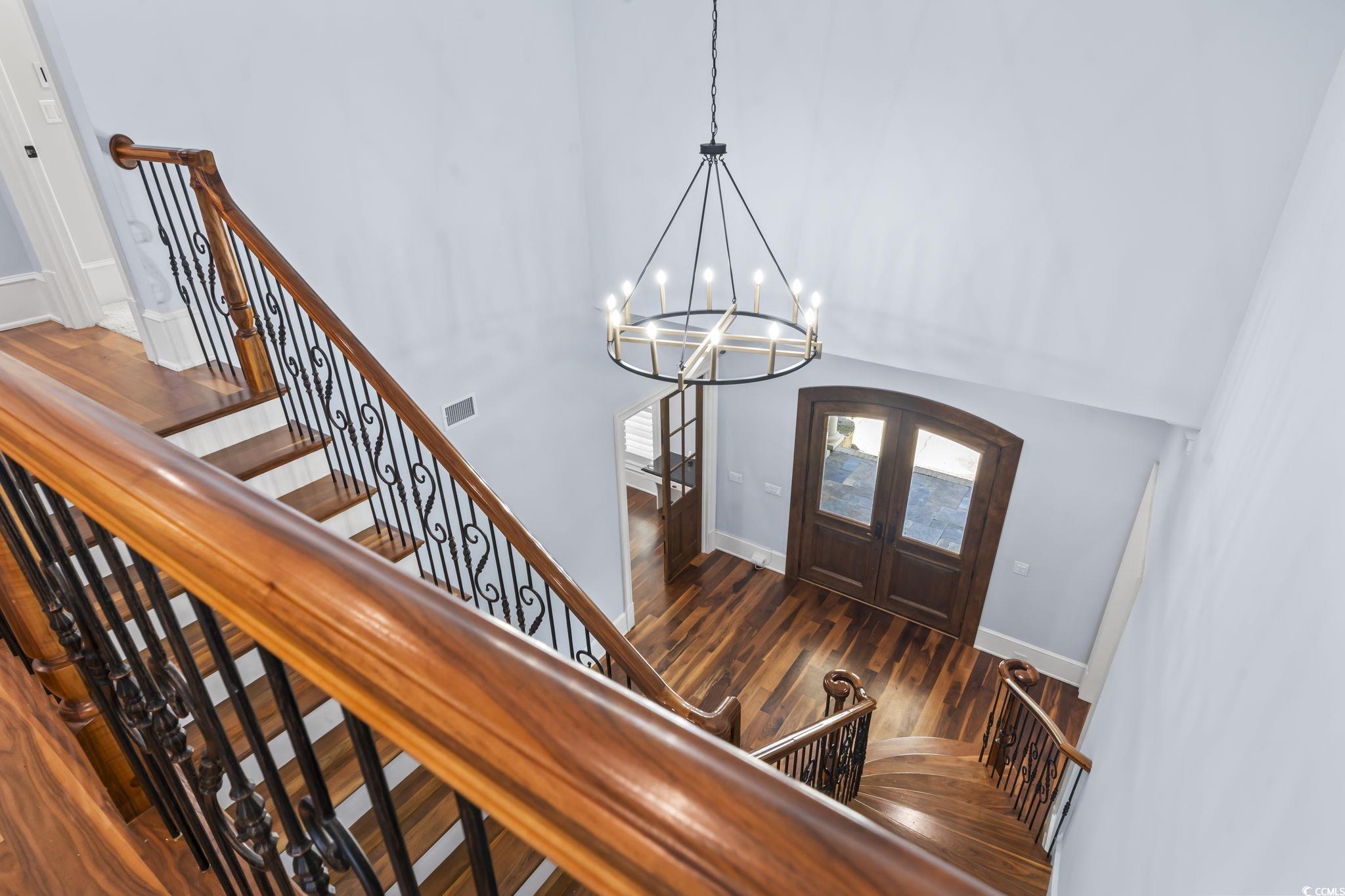 9318 Cove Drive Myrtle Beach, SC 29572 - Photo 22 of 40 Entrance foyer featuring french doors, dark wood-style floors, stairway, a chandelier, and a high ceiling