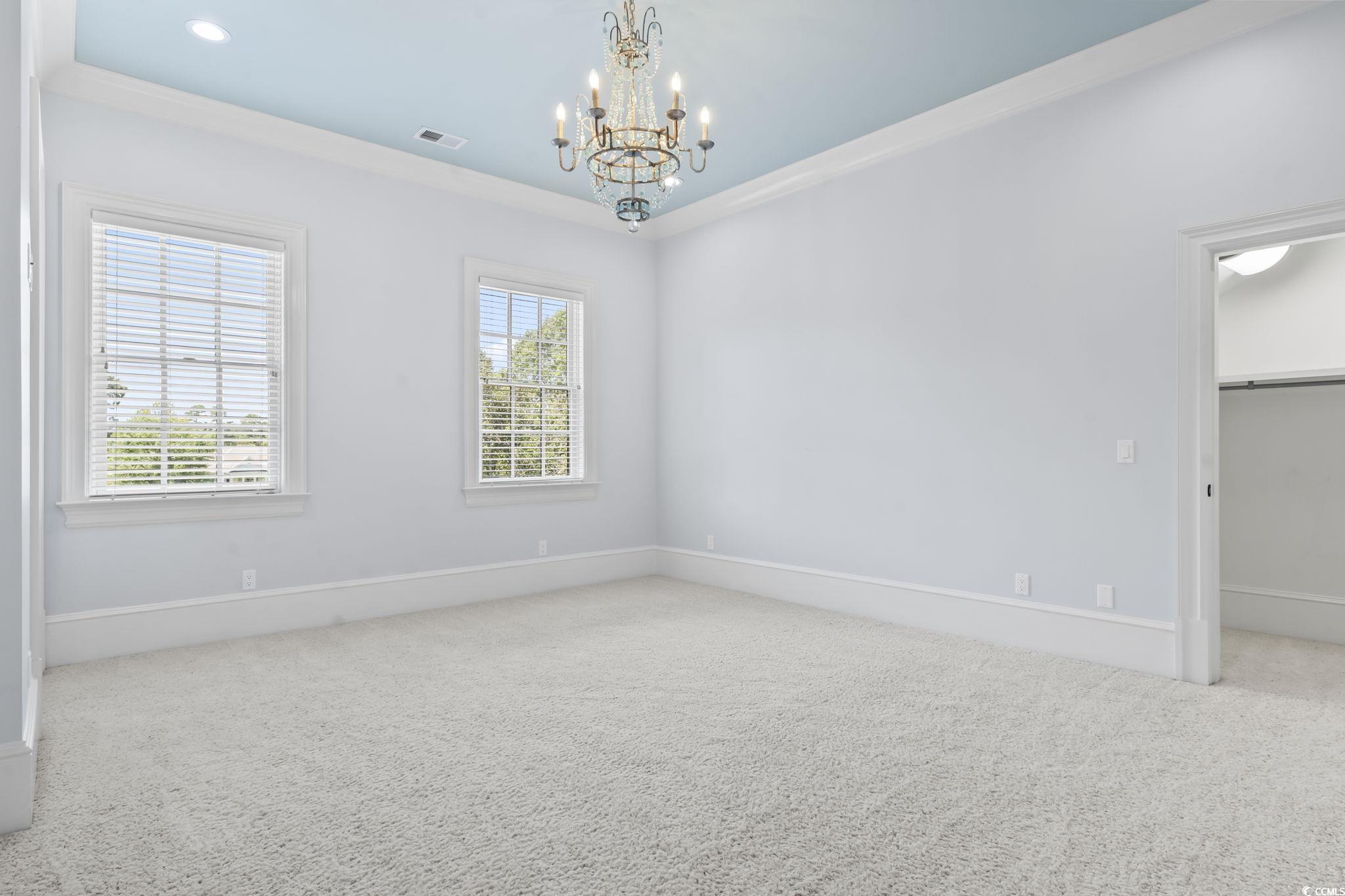 9318 Cove Drive Myrtle Beach, SC 29572 - Photo 29 of 40 Spare room with crown molding, carpet, and a chandelier