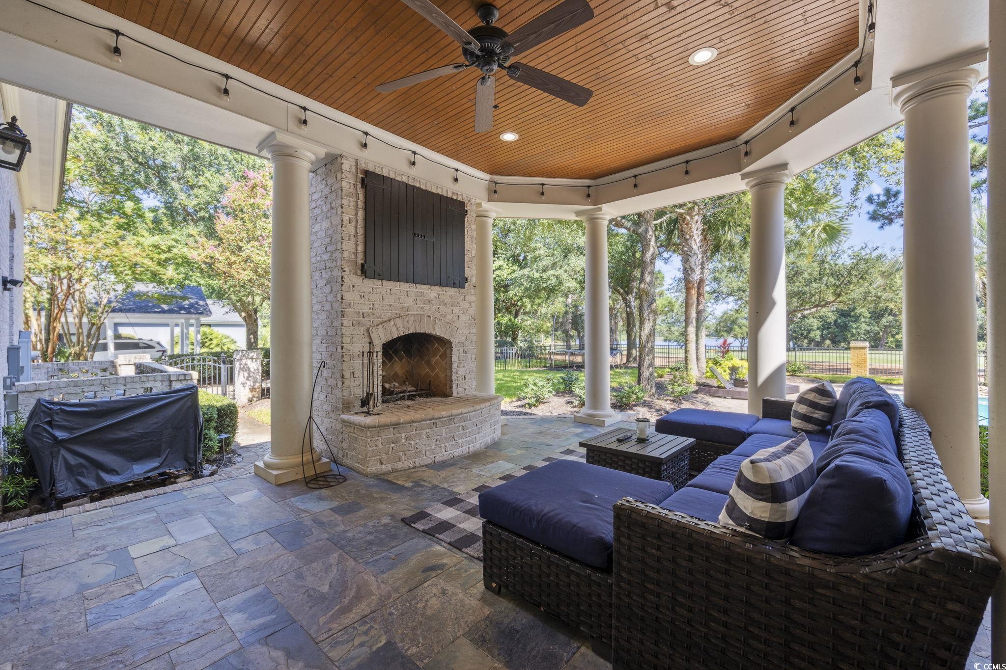 9318 Cove Drive Myrtle Beach, SC 29572 - Photo 36 of 40 View of patio / terrace with an outdoor living space with a fireplace and ceiling fan