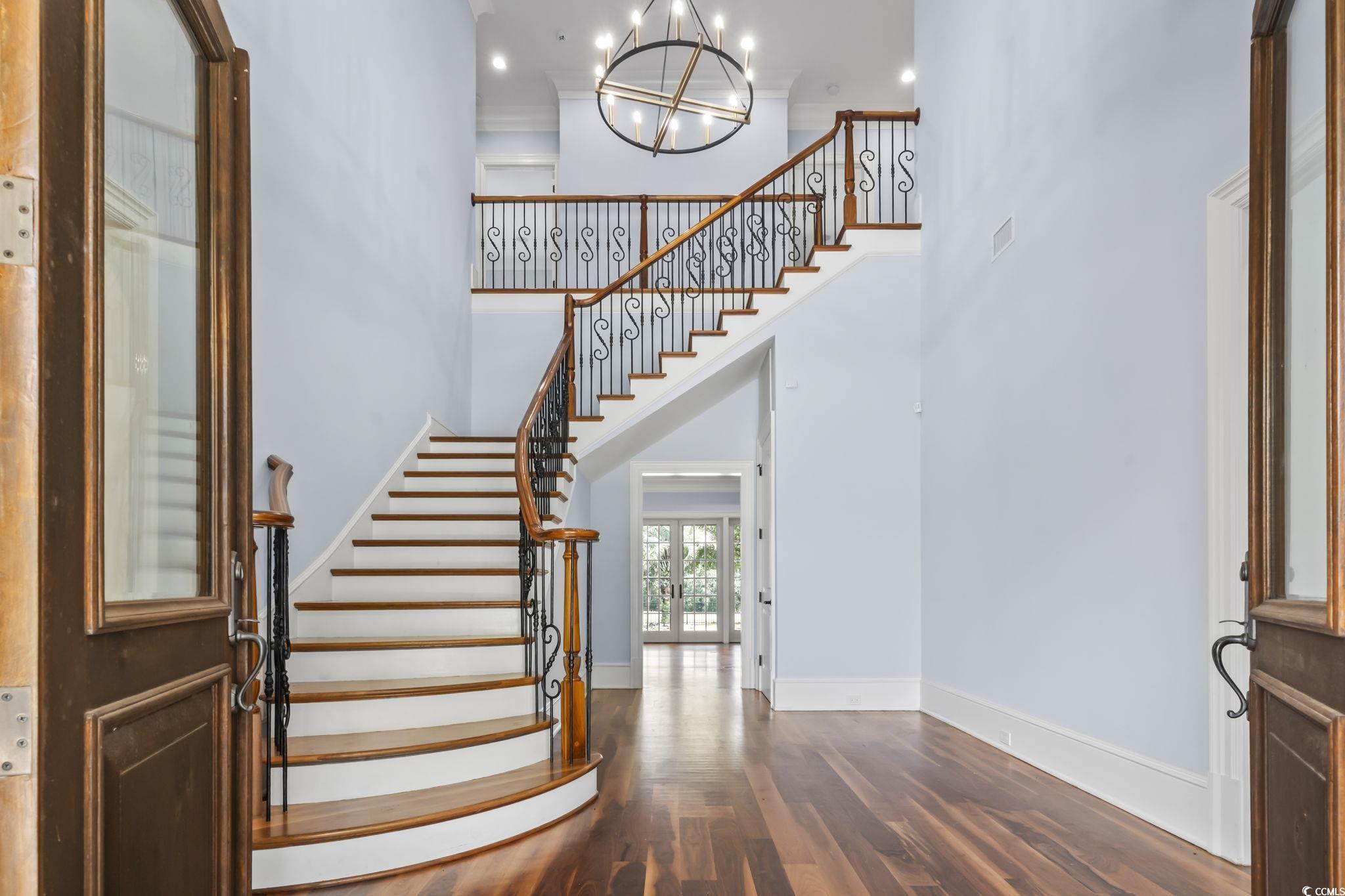 9318 Cove Drive Myrtle Beach, SC 29572 - Photo 7 of 40 Entryway featuring stairs, dark wood-type flooring, french doors, a high ceiling, and a chandelier