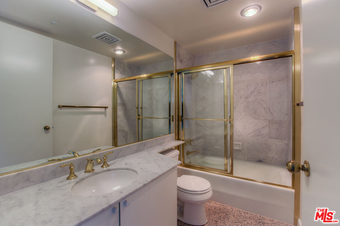 10520 Wilshire Boulevard, Unit 905 Los Angeles, CA 90024 - Photo 17 of 17 a bathroom with a granite countertop sink toilet and shower