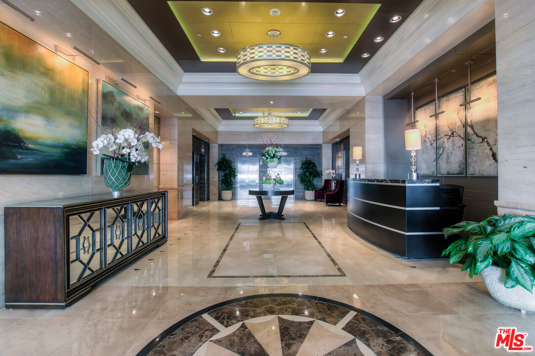 10520 Wilshire Boulevard, Unit 905 Los Angeles, CA 90024 - Photo 4 of 17 a living room with a couch and a chandelier