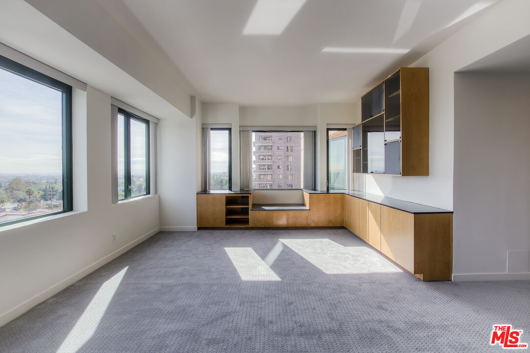 10520 Wilshire Boulevard, Unit 905 Los Angeles, CA 90024 - Photo 9 of 17 a view of an empty room with a window and a kitchen