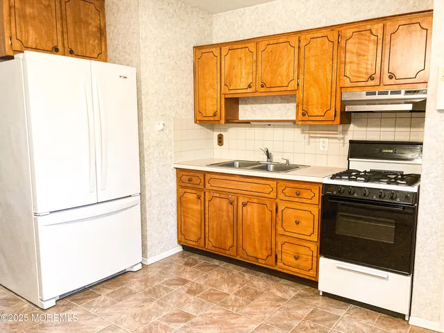 a kitchen with stainless steel appliances granite countertop a refrigerator and a stove
