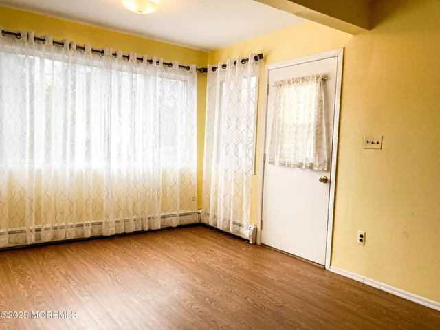 a view of a room with wooden walls and a window