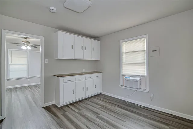 a view of a kitchen with wooden floor and cabinets
