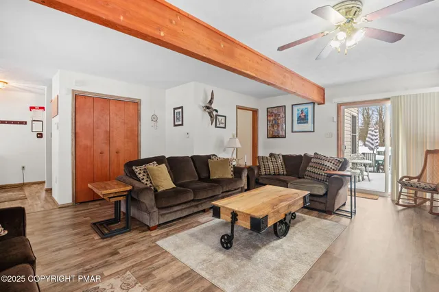 a living room with furniture a flat screen tv and a window