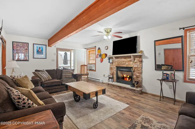 a living room with furniture a flat screen tv and a fireplace