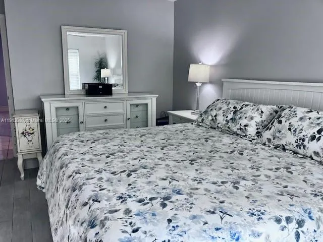 a bedroom with a bed and a mirror on dresser