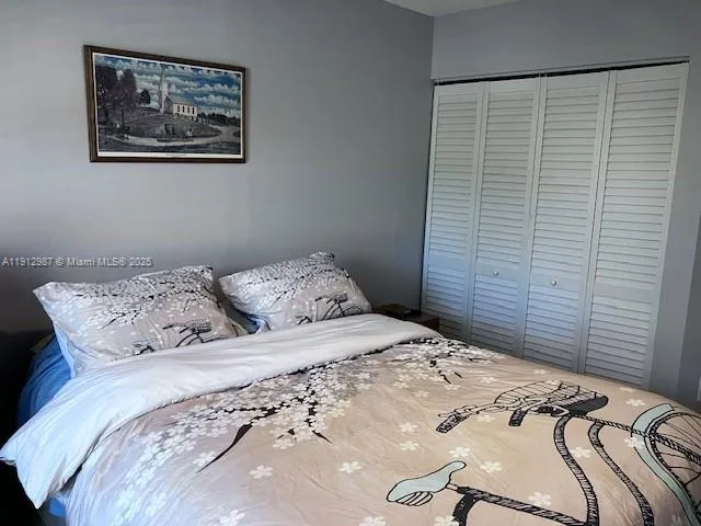 a bedroom with a bed and a painting on the wall