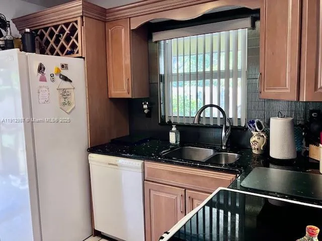 a kitchen with a refrigerator and a sink