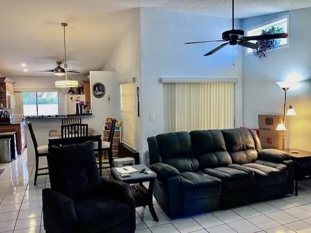 a living room with furniture a ceiling fan and a window