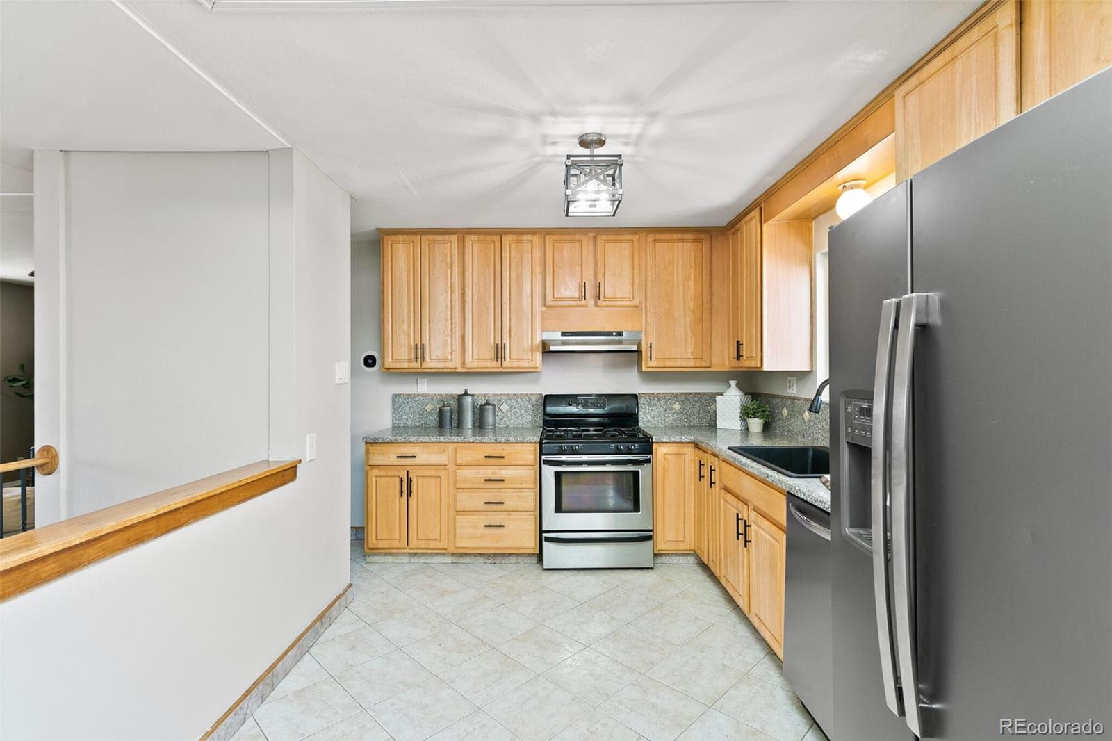 5500 Vale Drive Denver, CO 80246 - Photo 13 of 40 a kitchen with white cabinets and stainless steel appliances