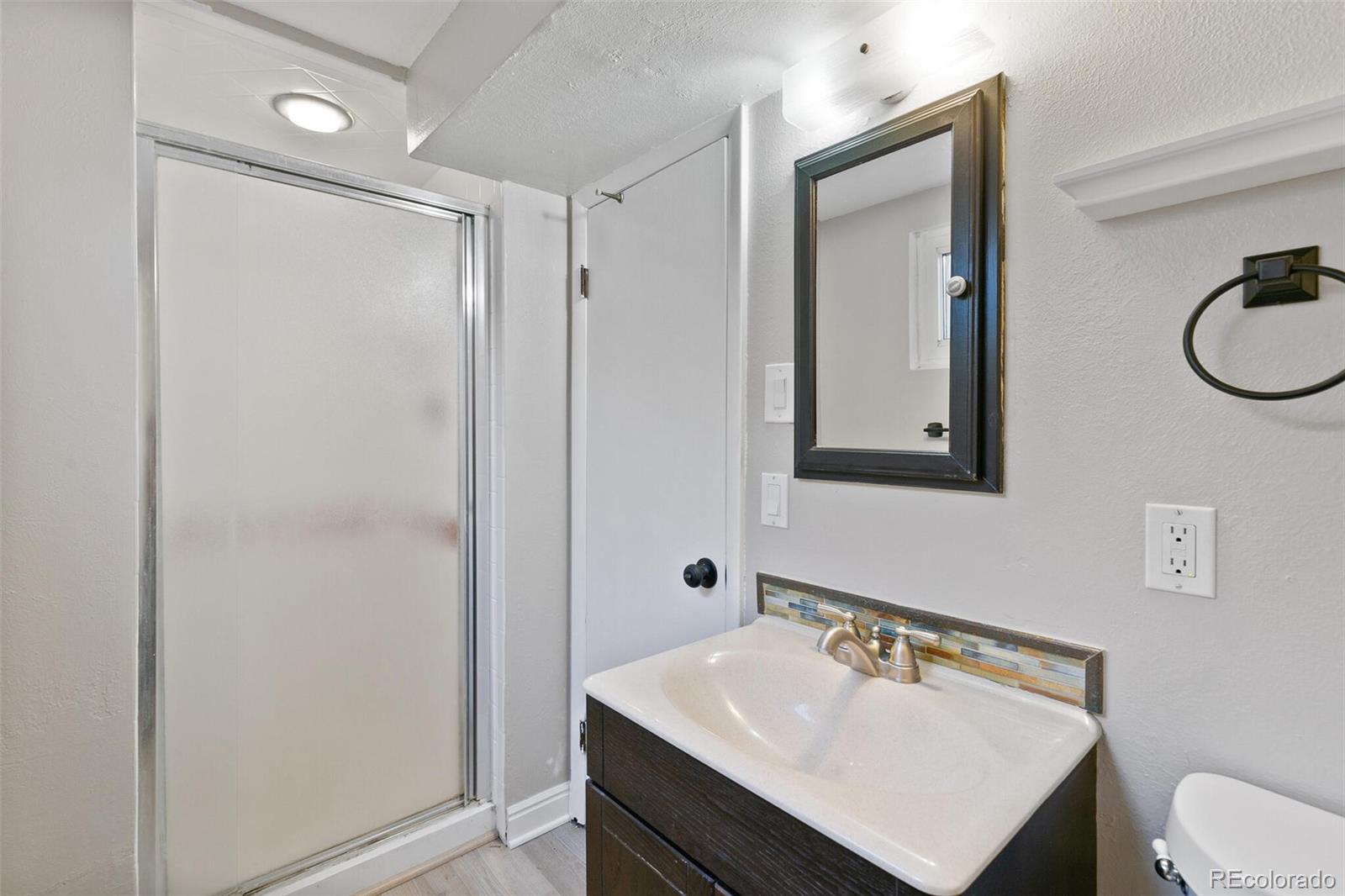 5500 Vale Drive Denver, CO 80246 - Photo 26 of 40 a bathroom with a sink mirror vanity and toilet