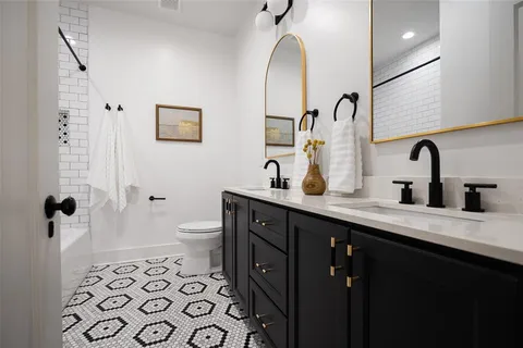 a bathroom with a double vanity sink mirror and toilet