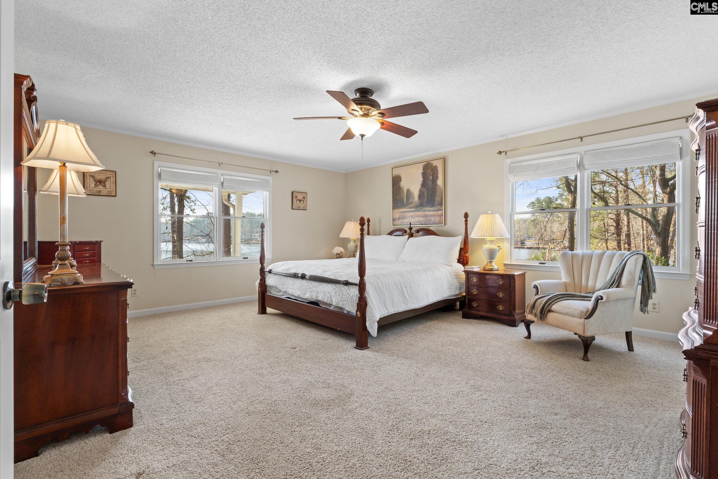 115 Rocky Ridge Road Leesville, SC 29070 - Photo 19 of 51 a bedroom with a bed and large windows