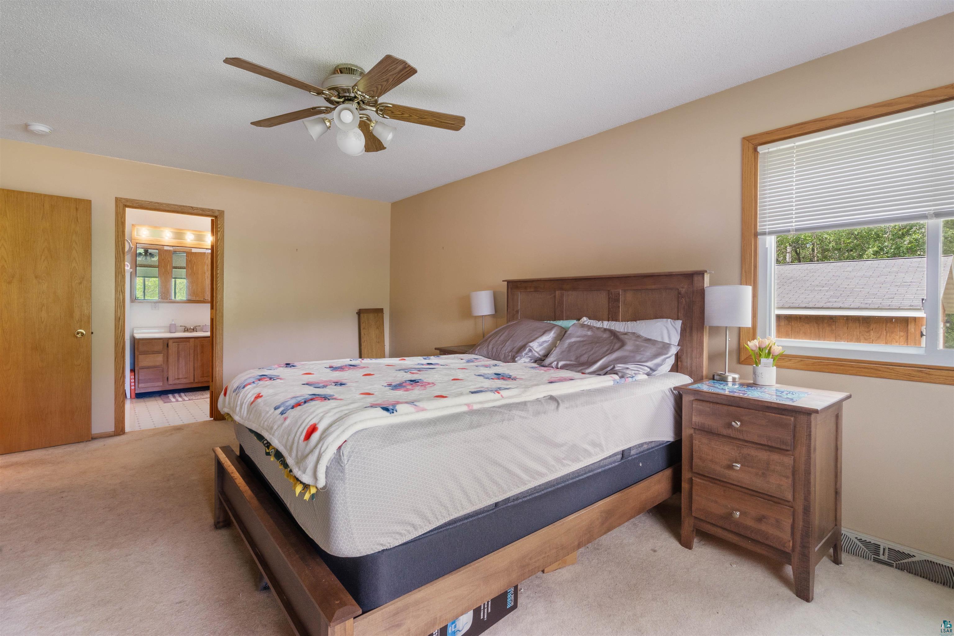 3711 Getchell Road Hermantown, MN 55811 - Photo 12 of 31 Bedroom featuring neutral wall color, wood-finish window trim, carpeted flooring, and a ceiling fan with integrated lighting
