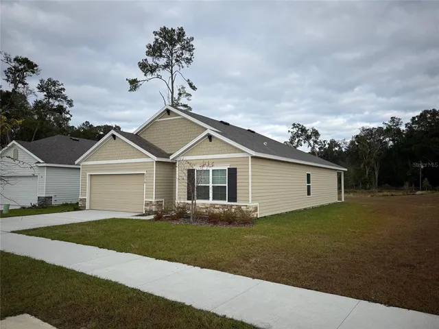 a front view of a house with a garden and yard