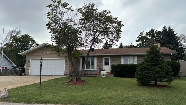 a front view of a house with a garden and yard