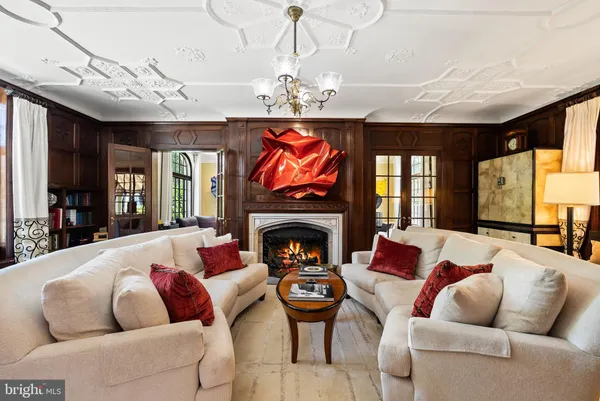 a living room with furniture a fireplace and a chandelier