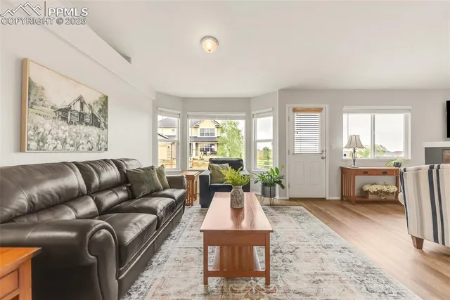 a living room with furniture a large window and a table