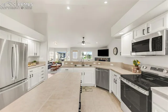 a large kitchen with a large counter top space appliances and cabinets