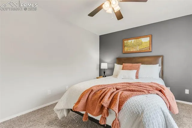 a bedroom with a bed and painting on the wall