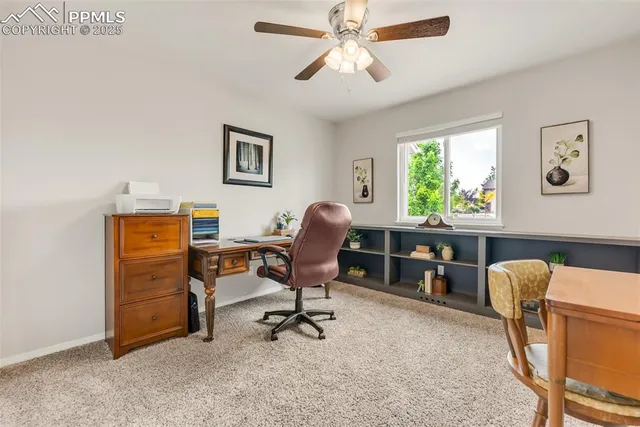 a view of a workspace with furniture and a window