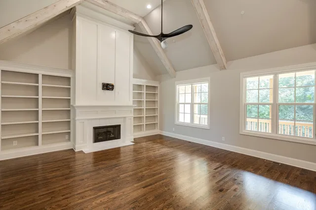 a kitchen with stainless steel appliances granite countertop a sink a stove a refrigerator and a wooden floor