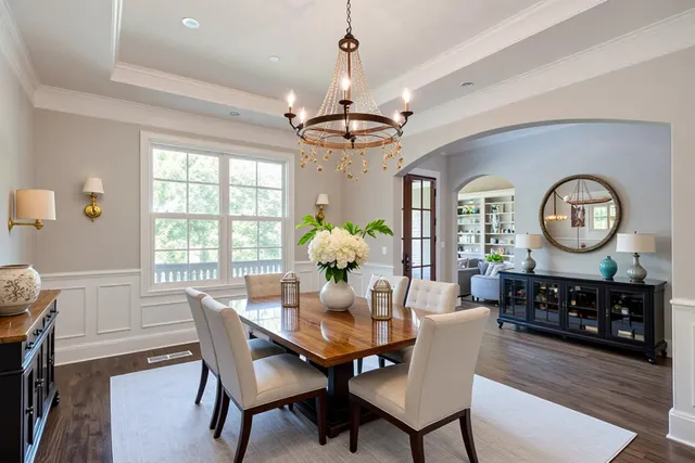 an empty room with wooden floor chandelier and windows