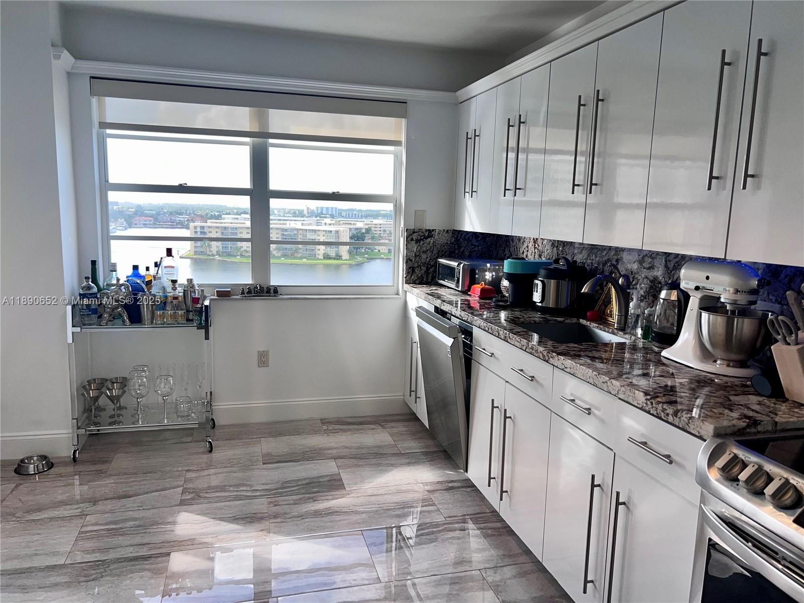2851 Northeast 183rd Street, Unit 1017E Aventura, FL 33160 - Photo 21 of 46 a kitchen with stainless steel appliances granite countertop a sink and cabinets