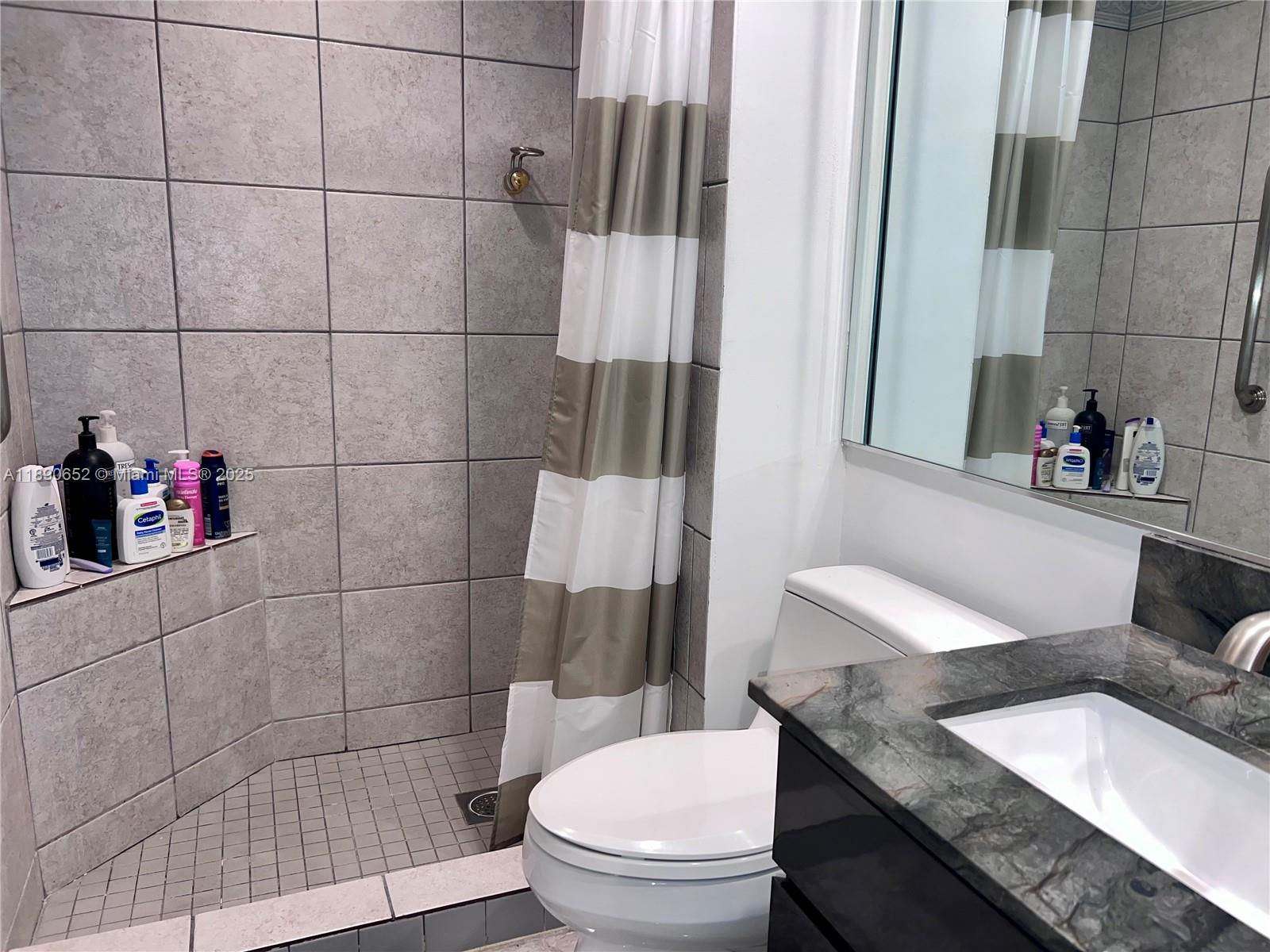 2851 Northeast 183rd Street, Unit 1017E Aventura, FL 33160 - Photo 31 of 46 a bathroom with a granite countertop sink and a toilet