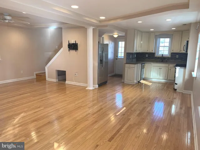 an empty room with wooden floor and fireplace