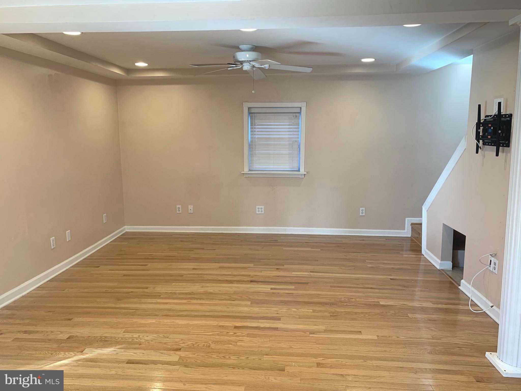781 Powhatan Beach Road Pasadena, MD 21122 - Photo 6 of 24 an empty room with wooden floor and fireplace