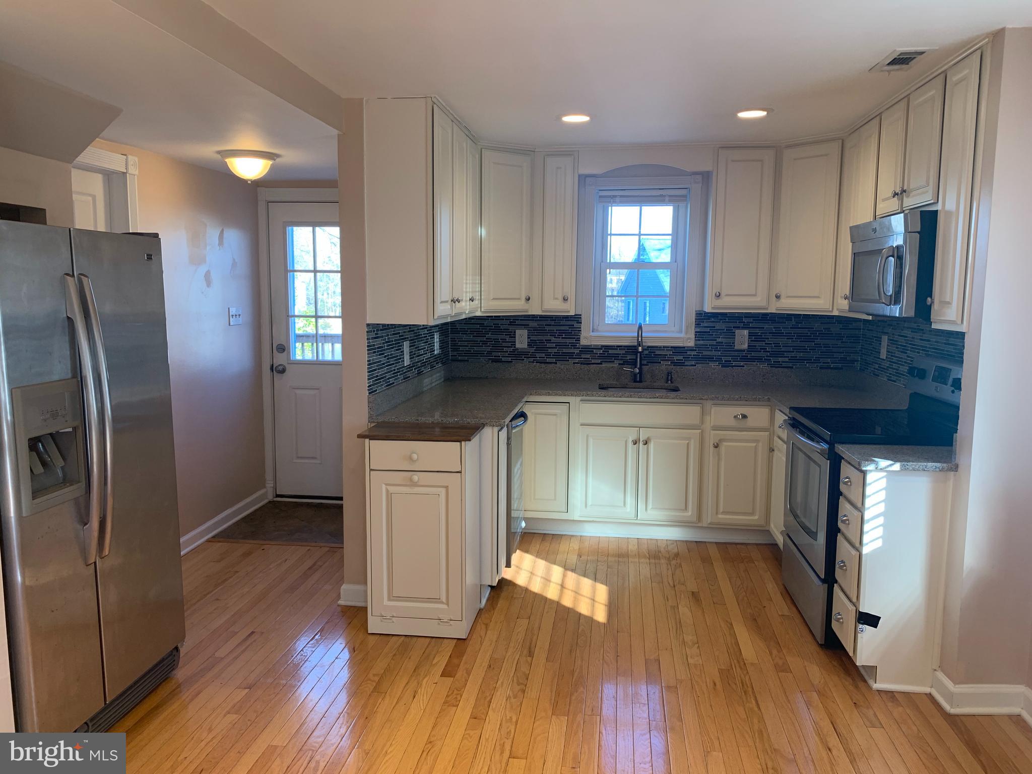 781 Powhatan Beach Road Pasadena, MD 21122 - Photo 7 of 24 a kitchen with granite countertop a sink cabinets and stainless steel appliances