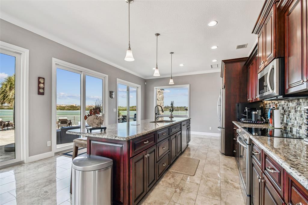 582 Johns Pass Avenue Madeira Beach, FL 33708 - Photo 20 of 100 a large kitchen with stainless steel appliances granite countertop a lot of counter space and a sink