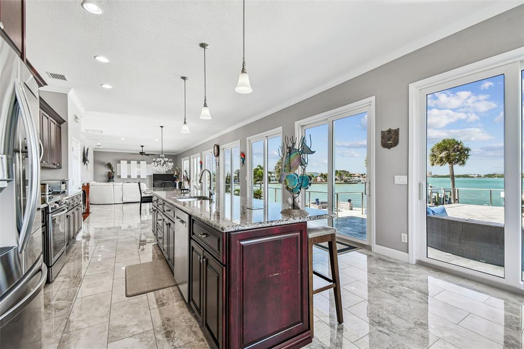 582 Johns Pass Avenue Madeira Beach, FL 33708 - Photo 23 of 100 a kitchen with stainless steel appliances granite countertop a refrigerator and a stove