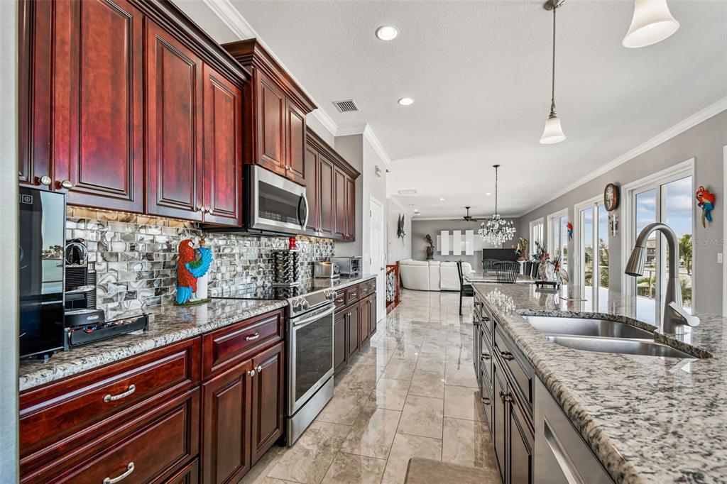582 Johns Pass Avenue Madeira Beach, FL 33708 - Photo 24 of 100 a kitchen with stainless steel appliances granite countertop a sink stove and cabinets