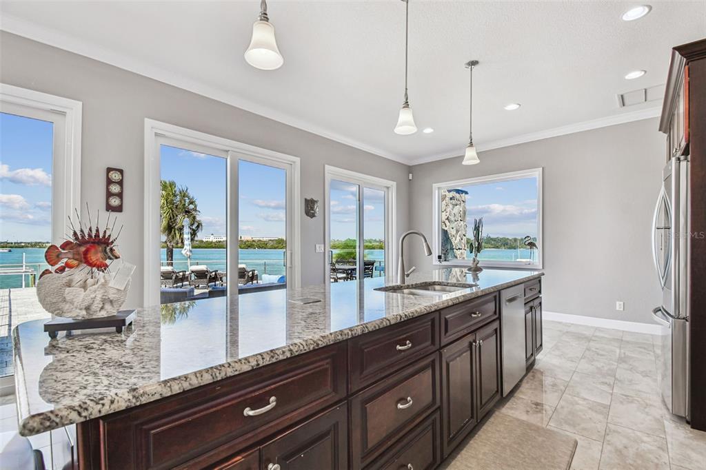 582 Johns Pass Avenue Madeira Beach, FL 33708 - Photo 26 of 100 a large kitchen with kitchen island granite countertop a large island in the center and a large window