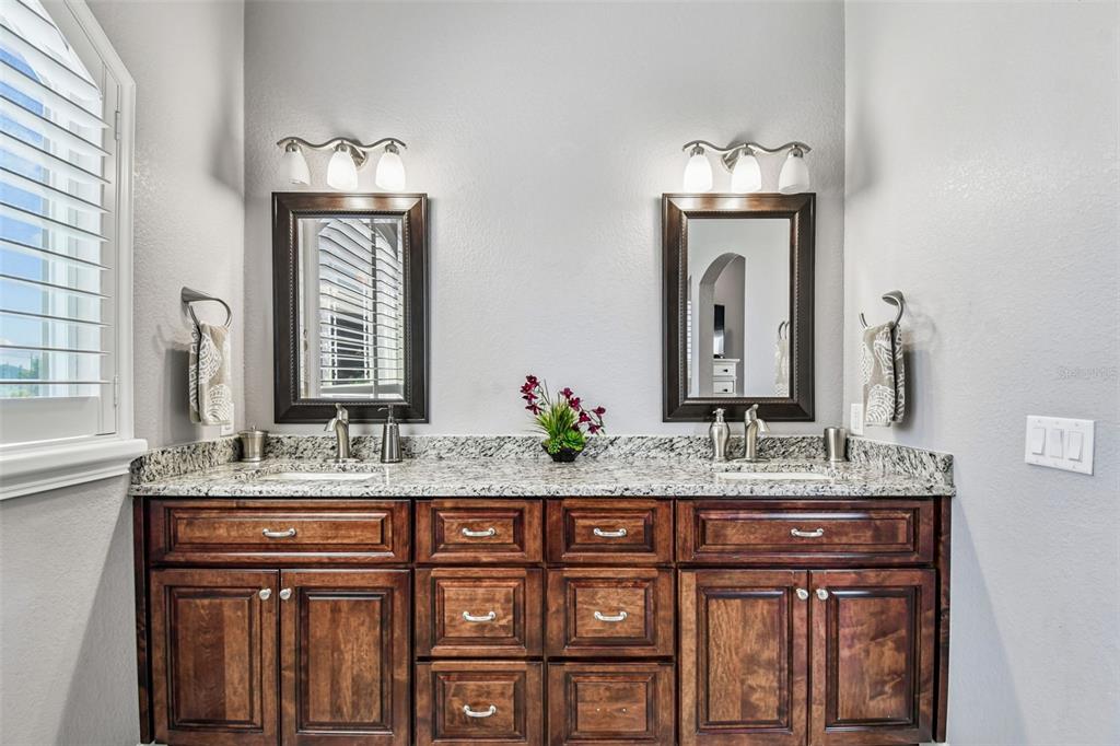 582 Johns Pass Avenue Madeira Beach, FL 33708 - Photo 50 of 100 a bathroom with a granite countertop double vanity sink and a mirror